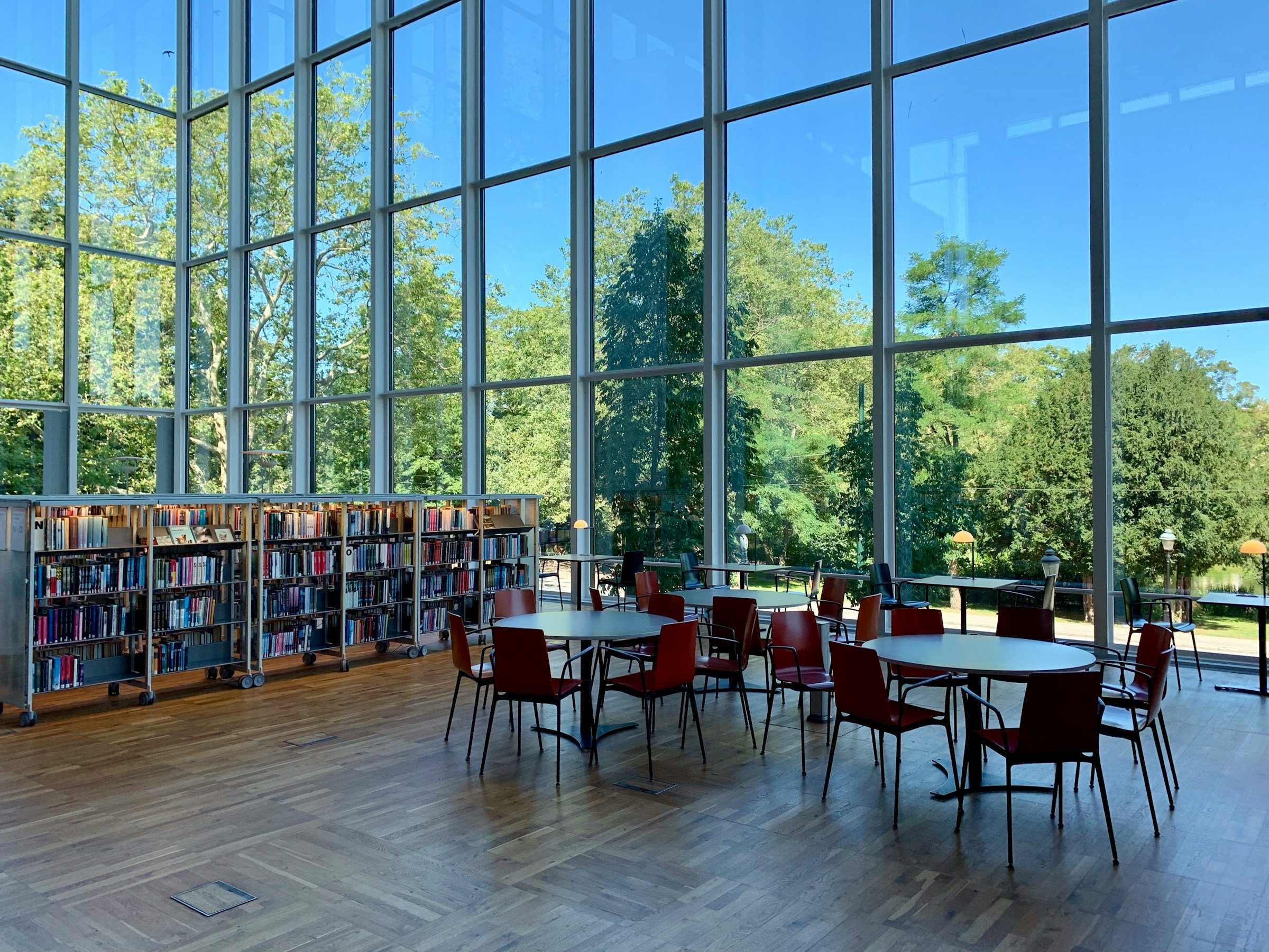 Ein Lesesaal mit Bücherregalen und Blick ins Grüne